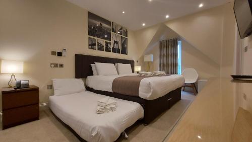 伦敦伦敦之星酒店的一间卧室配有两张带白色枕头的床