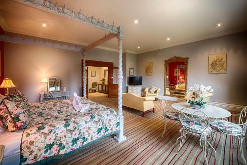 翰索Miskin Manor Hotel的一间带天蓬床的卧室和一间客厅
