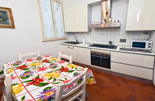 利沃诺Appartamento Borgo 98 Guest House的厨房配有一张桌子,上面有花卉桌布