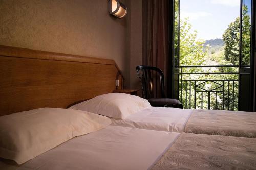 梅吕埃Logis Hôtel Restaurant Le Mont Aigoual的一间卧室设有两张床和一个美景窗户。