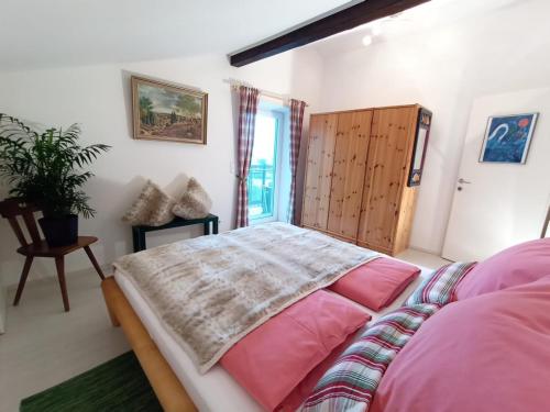 沃尔特湖畔韦尔登Schwalbennest Velden的一间卧室配有带粉红色枕头的床和窗户。