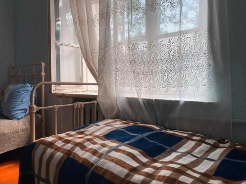 迪利然Ojakh的窗前的一张带窗帘的床