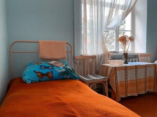 迪利然Ojakh的一间卧室配有一张带橙色毯子和窗户的床。