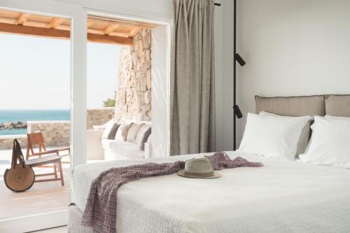 圣爱奥尼斯米科诺斯Casa Del Mar - Small Luxury Hotels of the World的一间卧室,配有一张床,上面有帽子