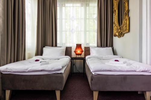 尤尔马拉Hotel Marino的酒店客房设有两张床和窗户。