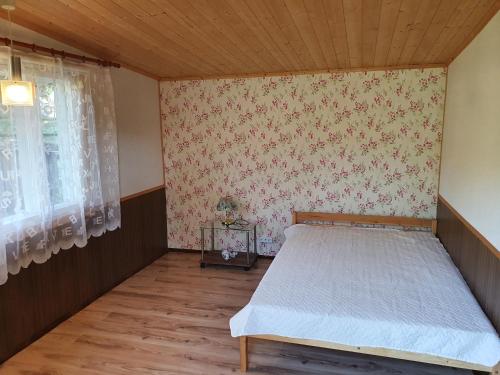 纳尔瓦约埃苏Suvemaja的卧室位于客房的角落,配有一张床