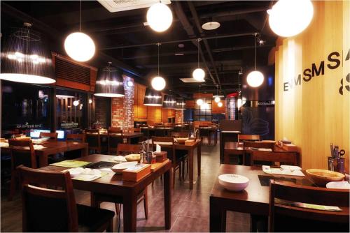 蔚山蔚山市酒店 的餐厅设有木桌和椅子及灯