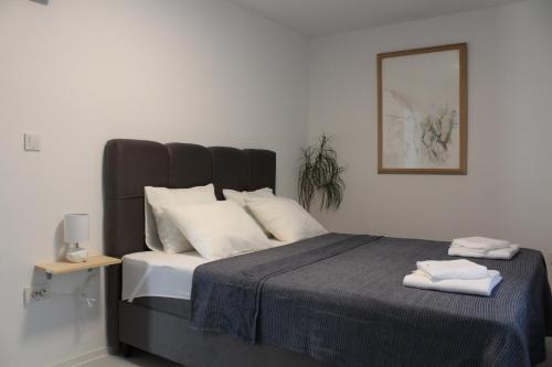 帕格Apartman Boki的卧室配有带白色枕头的大床