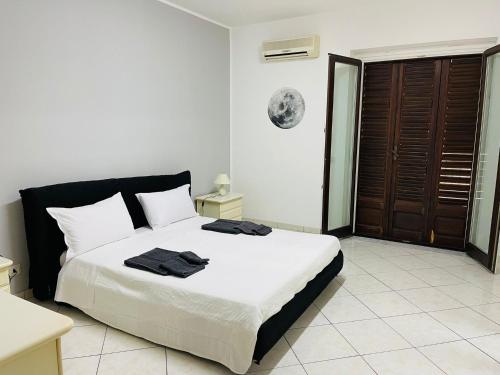 圣乔瓦尼镇IL QUADRIFOGLIO intero appartamento centro città的一间卧室配有一张带白色床单和黑色色调的大床。