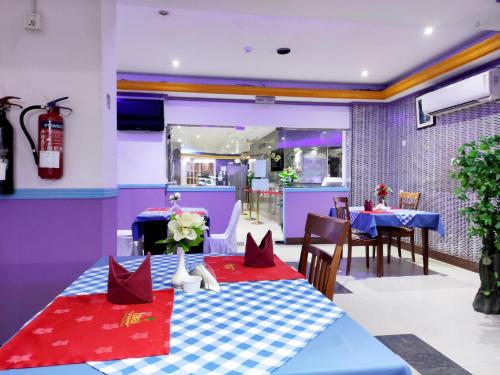 阿吉曼Al Rayan Hotel的一间用餐室,配有一张带红色餐巾的蓝色桌子