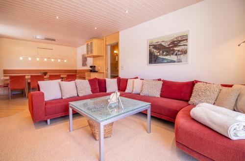 阿罗萨Sans Souci EG的客厅配有红色的沙发和桌子