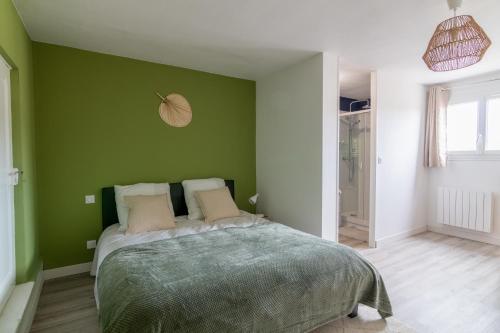 索米尔DUPLEX LE SAINT JEAN的一间卧室设有绿色的墙壁和一张床