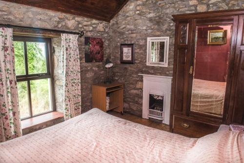 基拉尼Hillside View Holiday Home的一间卧室配有一张床和一个壁炉