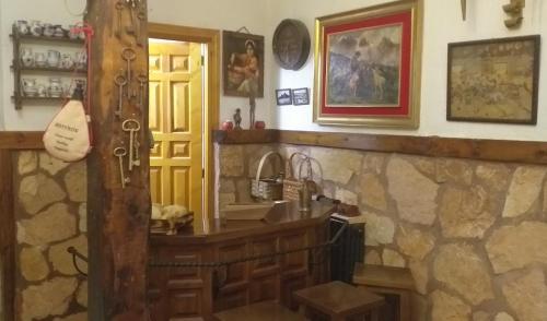艾利翁BOTEROS casa rural的一间设有石墙的房间,里面设有一个柜台