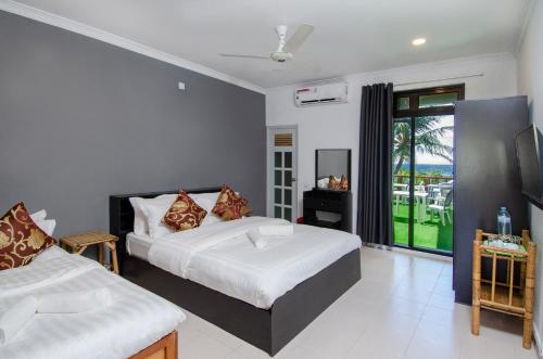 马富施Paradise Retreat, Maafushi的一间卧室设有两张床和窗户。