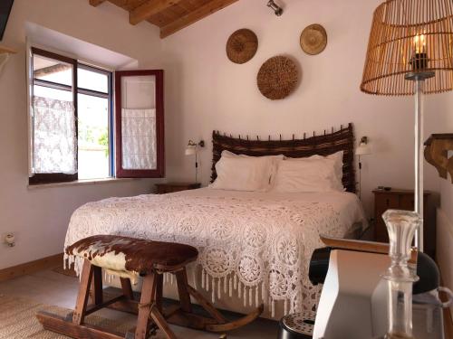 梅利迪什Ponte Pedra - Melides Country House Adults Only的一间卧室配有一张床、一张桌子和一个窗户。