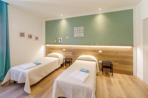 福利尼奥Dama Bed & Breakfast的一间设有三张床和绿色墙壁的客房