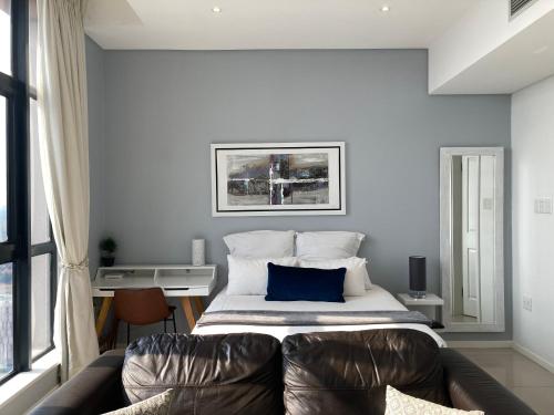 哈博罗内Urban Awe Apartment-iTowers 23rd Floor的一间卧室配有一张带蓝色枕头的床