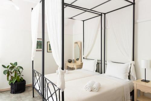 奥林匹亚达德国酒店的一间卧室配有一张带白色床单的四柱床