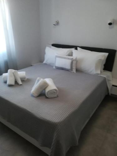 依诺罗达Aiolos Blu Luxury Apartments的一张大床,配有2条毛巾和枕头