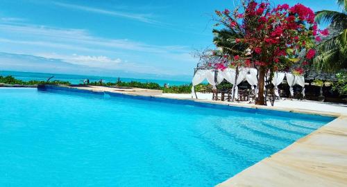 江比阿丽城度假酒店的一个带蓝色水和白色遮阳伞的游泳池