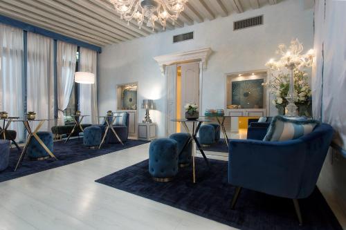 威尼斯黎莱斯威尼斯酒店的客厅配有蓝色椅子和吊灯。