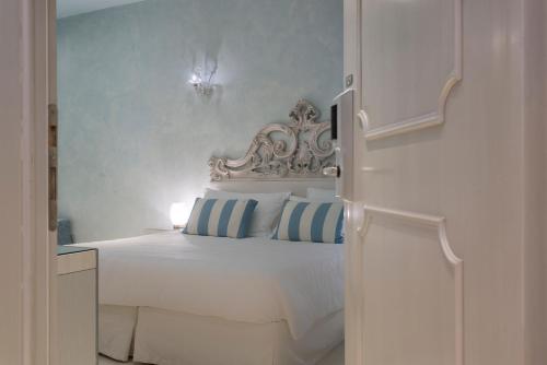 威尼斯黎莱斯威尼斯酒店的卧室配有白色床和蓝色的墙壁