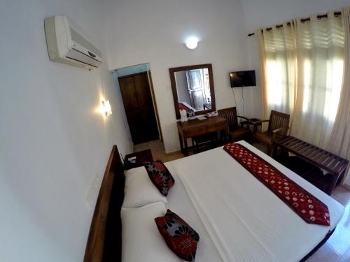 安伯朗戈德Ramon beach resort的卧室配有带红色枕头的大型白色床