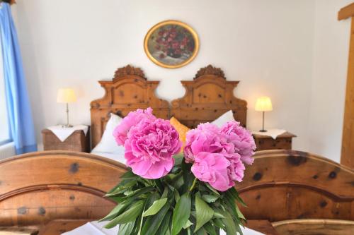 哈尔施塔特Gasthof Simony Hallstatt B&B的一张桌子上一束粉红色的花瓶