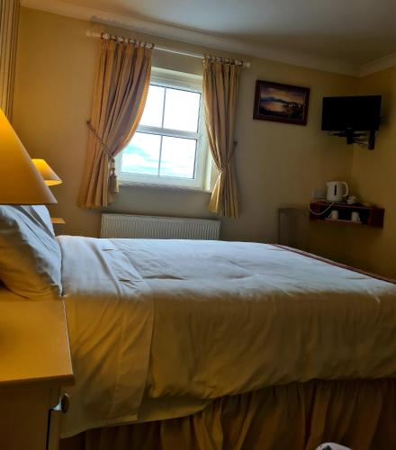 诺克Archmor house B&B的一间卧室设有一张大床和一个窗户。