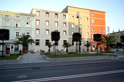 尼萨Hotel Piast的一条城市街道,道路前方有建筑和棕榈树