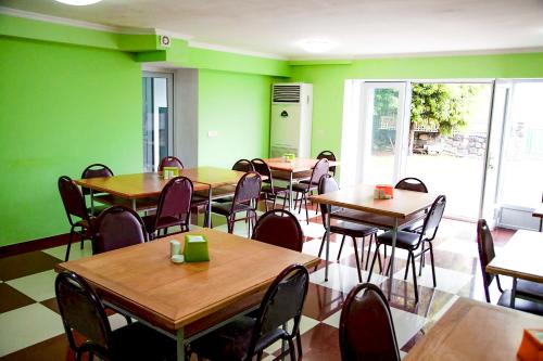 谢赫维蒂利Hotel "Qeti"的餐厅设有桌椅和绿色的墙壁