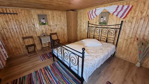阿尔杰什河畔库尔泰亚Lângă Stână的卧室配有一张床铺,位于带木墙的房间内