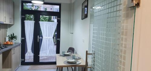 皮亚特拉-尼亚姆茨D&Y Studio- Piatra Neamț的厨房配有桌子,门通往阳台