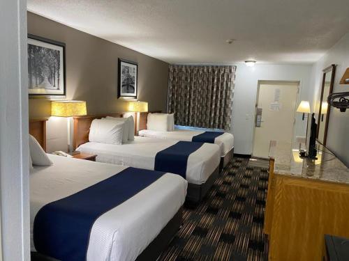 桑达斯基Cedar Cove的酒店客房设有三张床和电视。