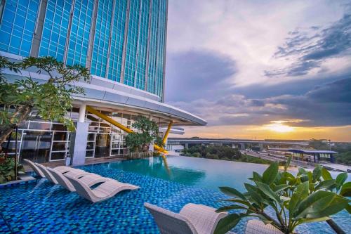 芝卡朗Nuanza Hotel & Convention Cikarang的一座带椅子的建筑屋顶上的游泳池