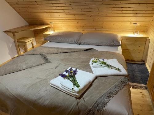 博希尼Miha`s cottage的一间卧室配有两张床、毛巾和鲜花