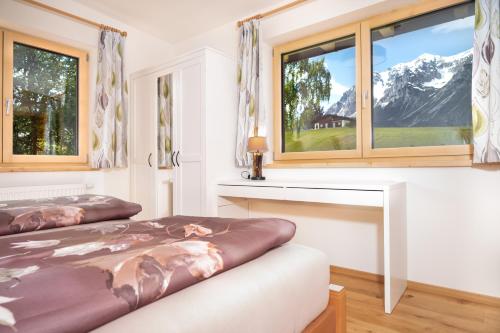 拉姆绍达赫斯坦Appartement Sonnenheim的一间卧室设有两张床和两个窗户。