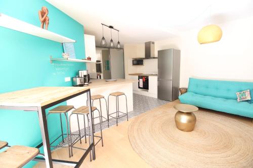 里昂Mon Appart A VILLON-MONPLAISIR的厨房以及带蓝色沙发的客厅。