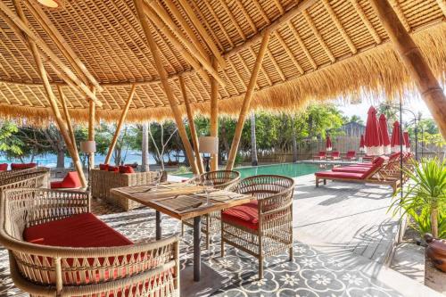 吉利阿萨汉Amahelia Luxury Resort & Restaurant - Gili Asahan的一个带桌椅的庭院和一个游泳池