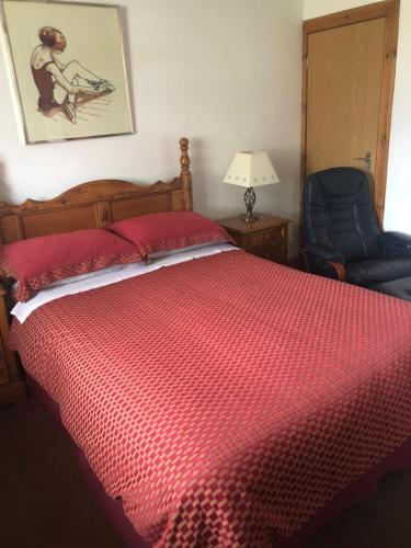 巴斯盖特Room @ Jasmine Cottage的一间卧室配有红色的床和蓝色椅子