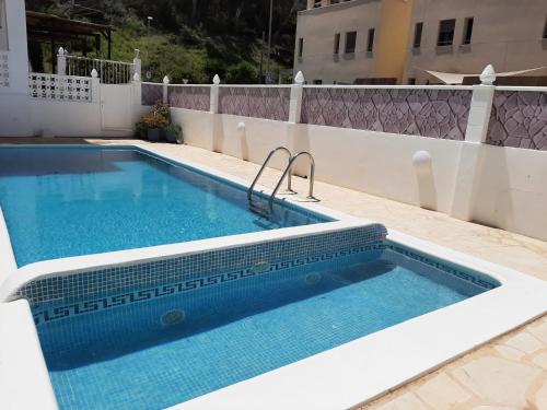 卡拉隆加Apartamentos Torres Cardona (Playa)的房屋一侧的游泳池