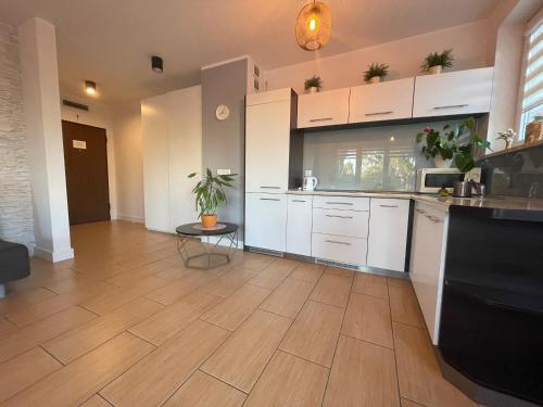 加茨比亚格拉Villa Nord的厨房铺有木地板,配有白色橱柜。