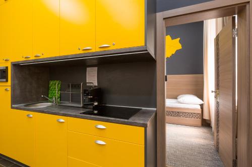 布达佩斯E14设计旅馆 的厨房配有黄色橱柜和水槽