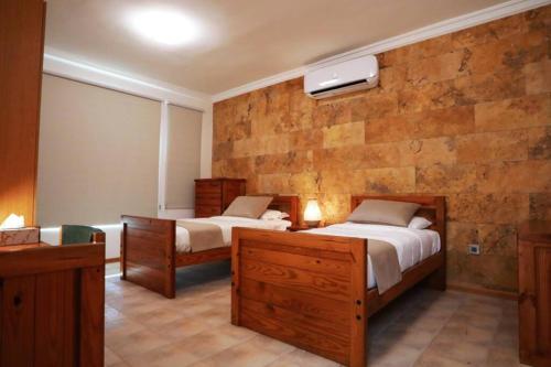 索瓦马Villa Sea Breeze的一间卧室设有两张床和石墙