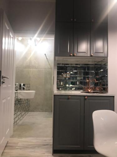 华沙Luxury Wola Apartament的厨房配有黑色橱柜和水槽