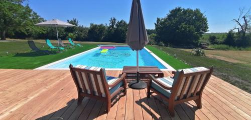 GuillacDomaine de Gaïa, Piscine, Pétanque, Ping-pong, proche Saint Emilion的游泳池旁的甲板配有两把椅子和一把遮阳伞
