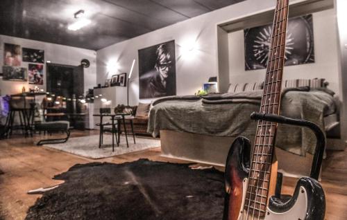 HaachtBackstage的卧室配有吉他,位于床边