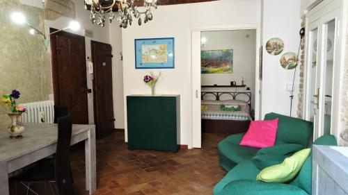 斯波莱托Non ditelo al Duca - Belvedere Sant'Angelo的客厅配有绿色沙发和桌子