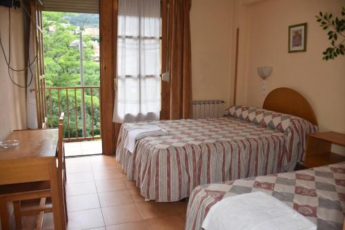圣洛伦索-德埃斯科里亚尔Hotel Tres Arcos的酒店客房设有两张床和一个阳台。
